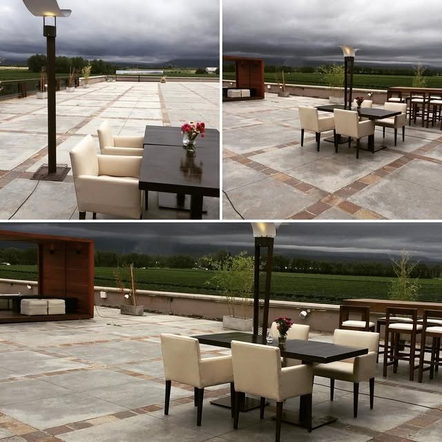 Terraza con mesas y sillas frente a viñedos